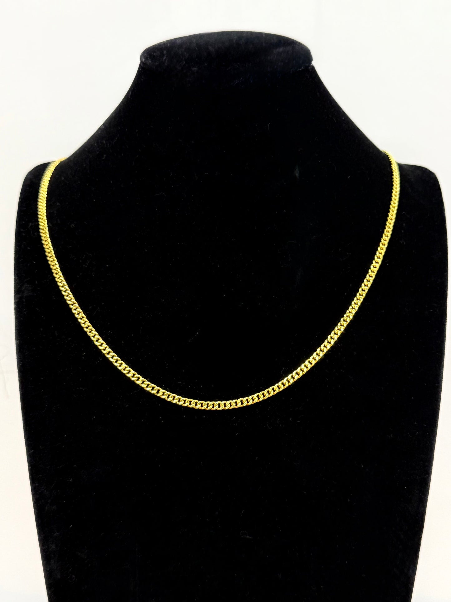 MIami cuban 24k Gold chain necklace on a black mannequin bust against a white background