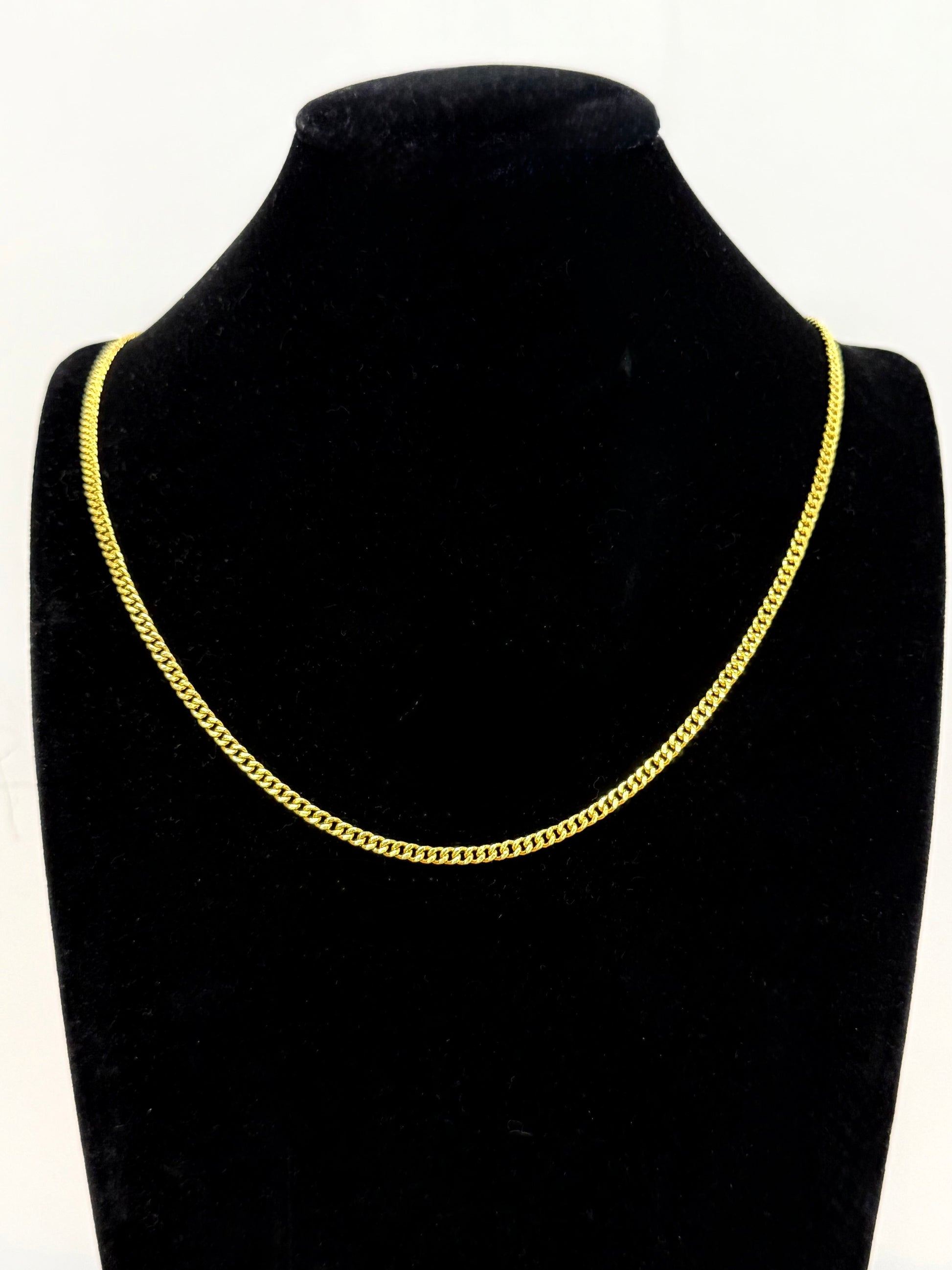 MIami cuban 24k Gold chain necklace on a black mannequin bust against a white background